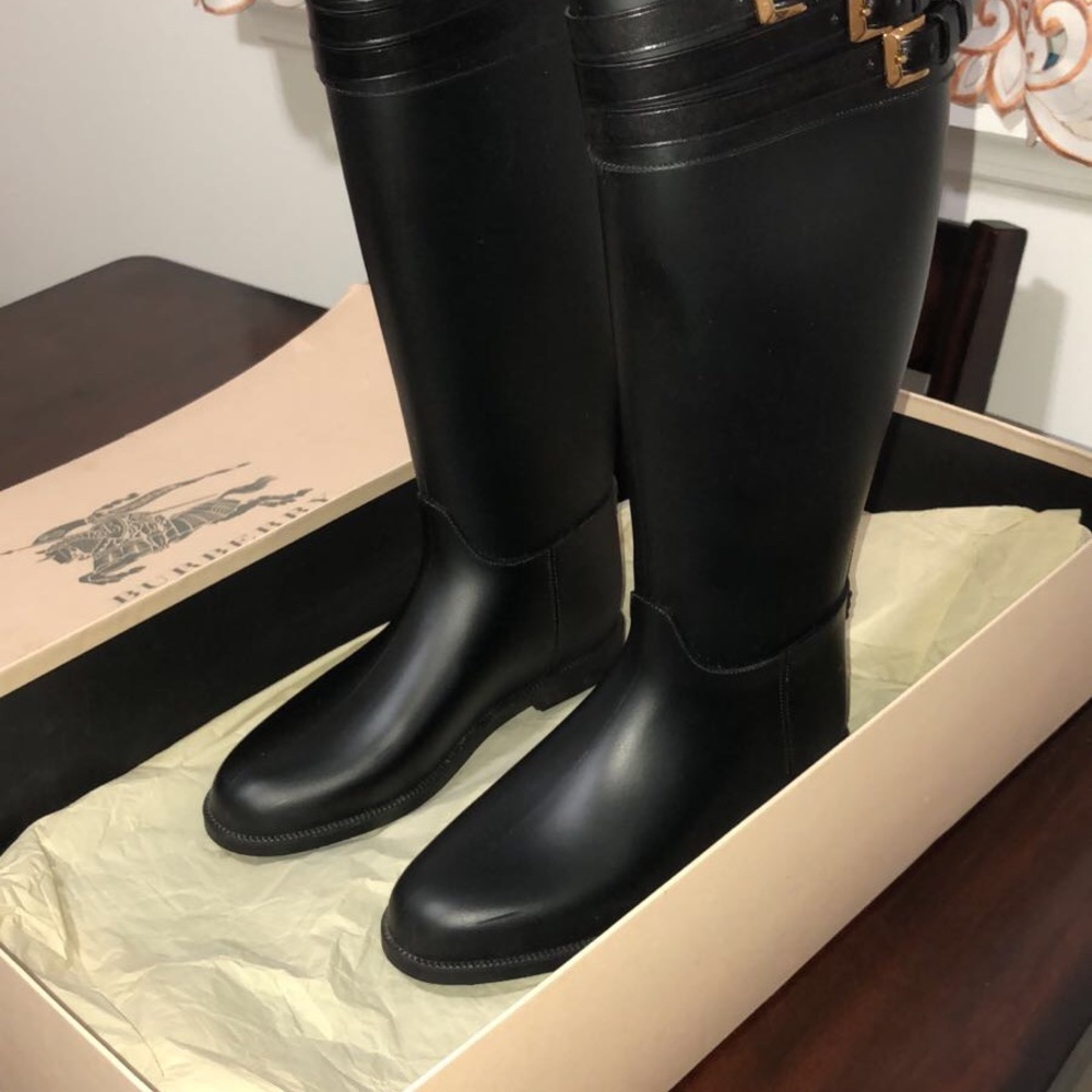 Burberry rain boots black with gold buckles.